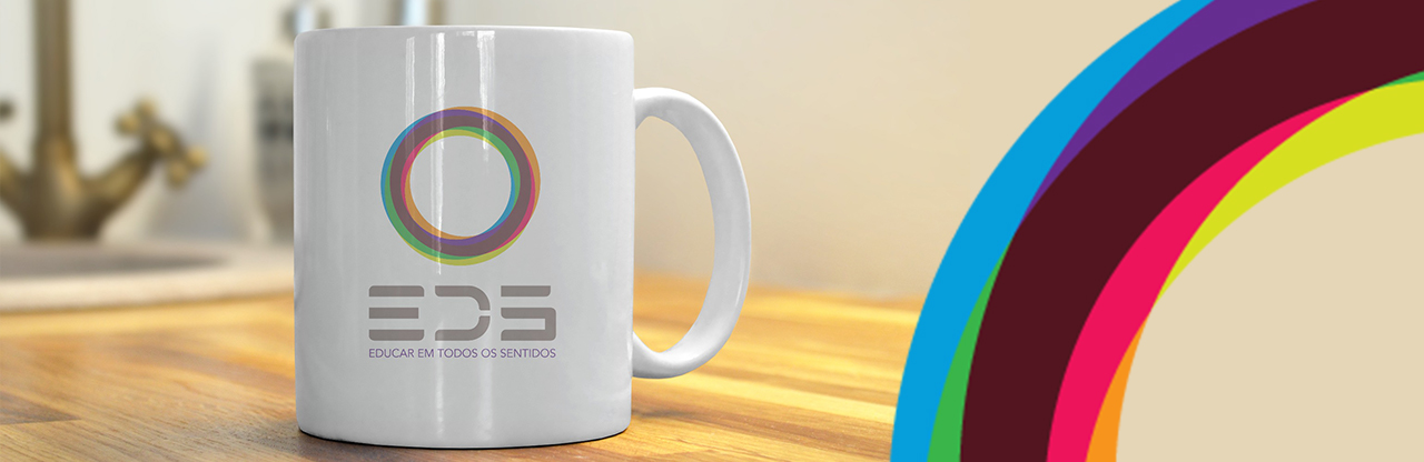 Foto de uma caneca na mesa com círculo colorido do logo ED5 ao lado.